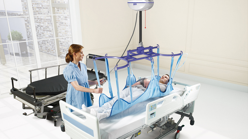 ArjoHuntleigh-patient-transfer-solutions-ceiling-lift-caregiver-with-patient-maxi-sky-2